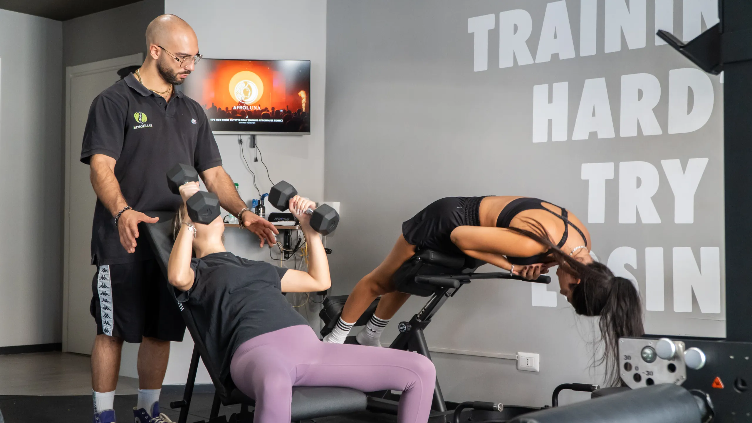 Allenamento con manubri e hyperextension seguito dal personal trainer